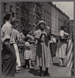 woman playing a tambourine in Harlem, ca. 1940s